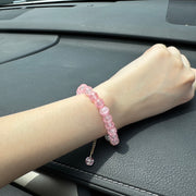 Handmade pink crackle beaded bracelet with white flower charm, gold crystals, and dangling bead, displayed in a gift box